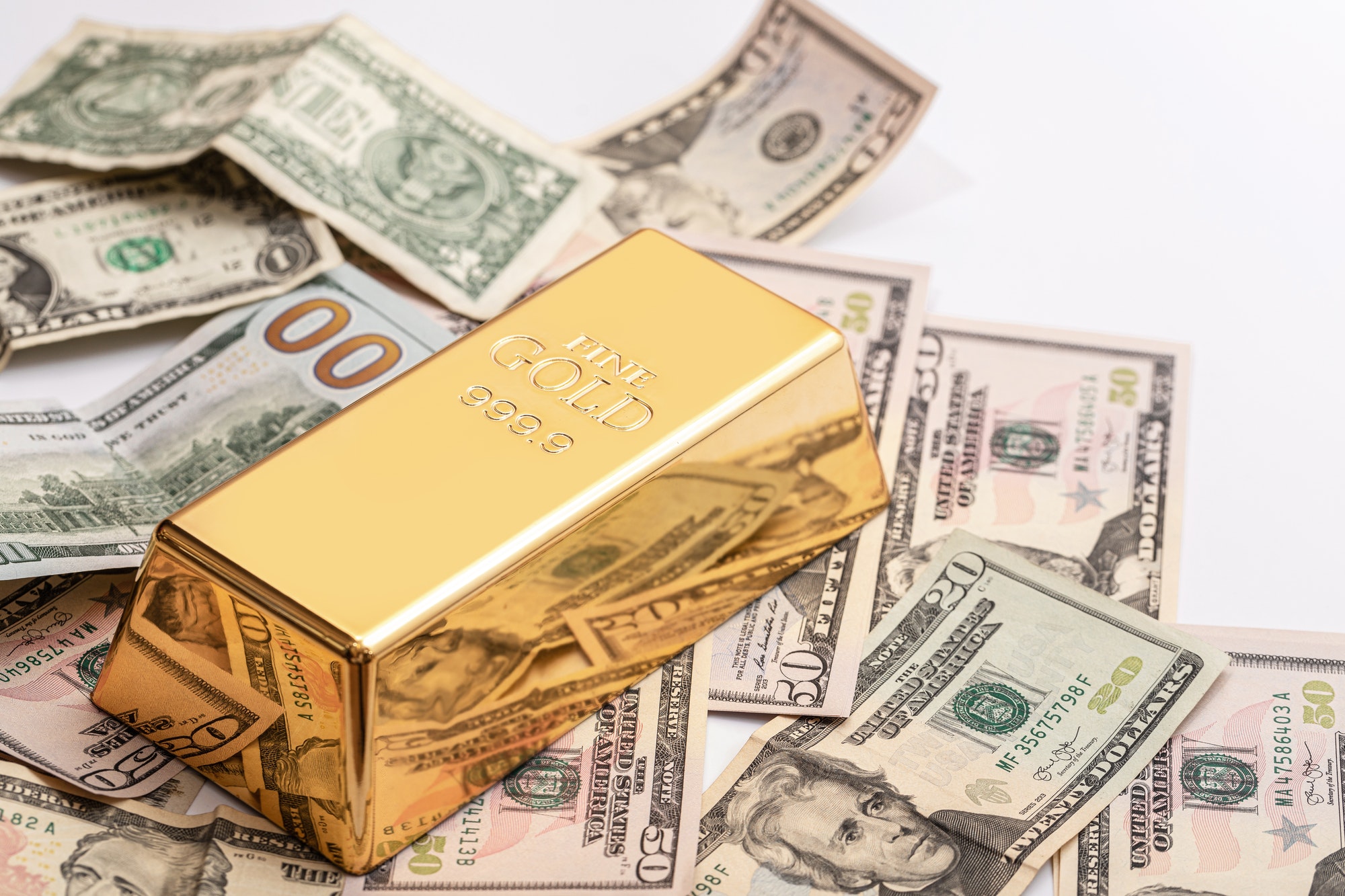 Expensive gold bar and US dollar bills