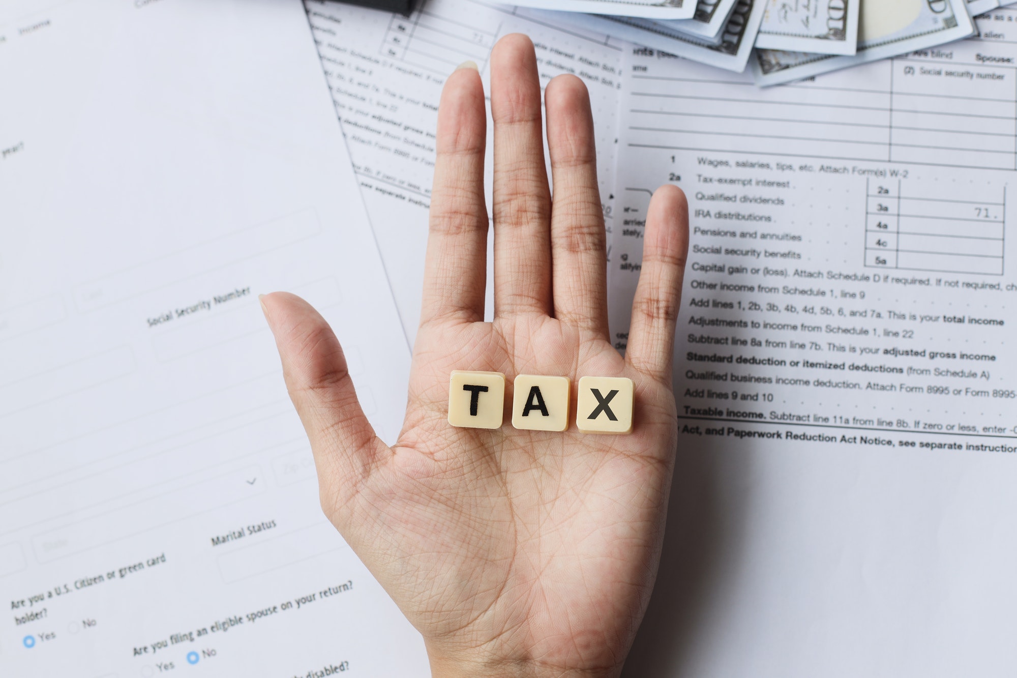 TAX words on palm hands against the tax forms.